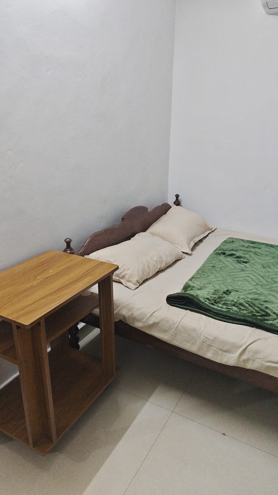 Inside a Dharshana bedroom with a green blanket