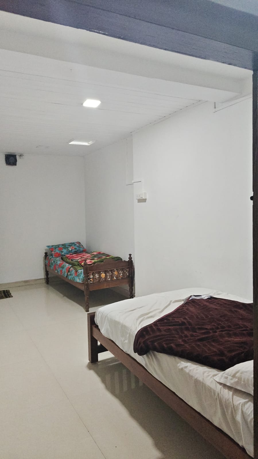 Inside a Dharshana room with two wooden beds