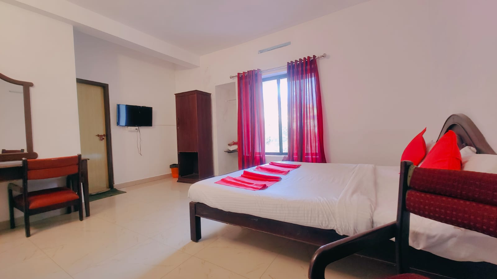 Inside a Lumino Karthika double room with red curtains